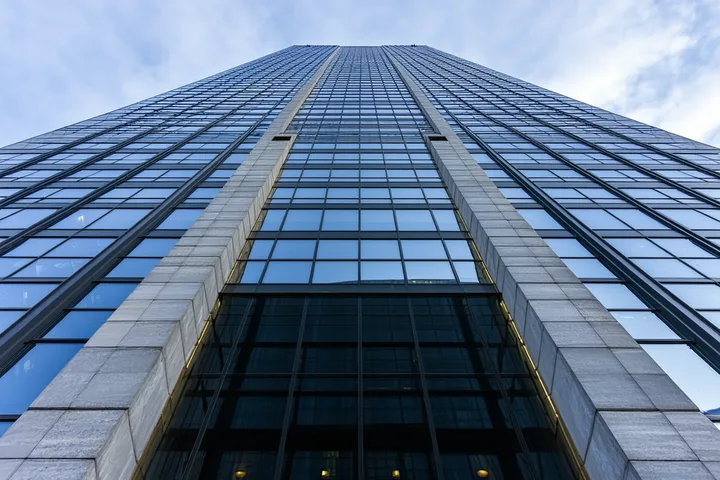 Commercial real estate building exterior, institutional office tower with glass and stone facade